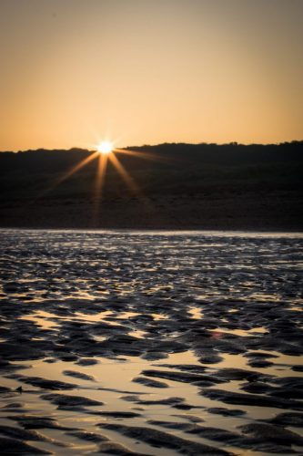 Sonne schaut über die Dünen